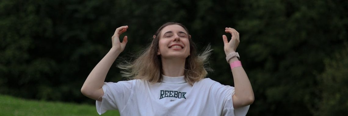 the happy girl smiles and rejoices in the rain